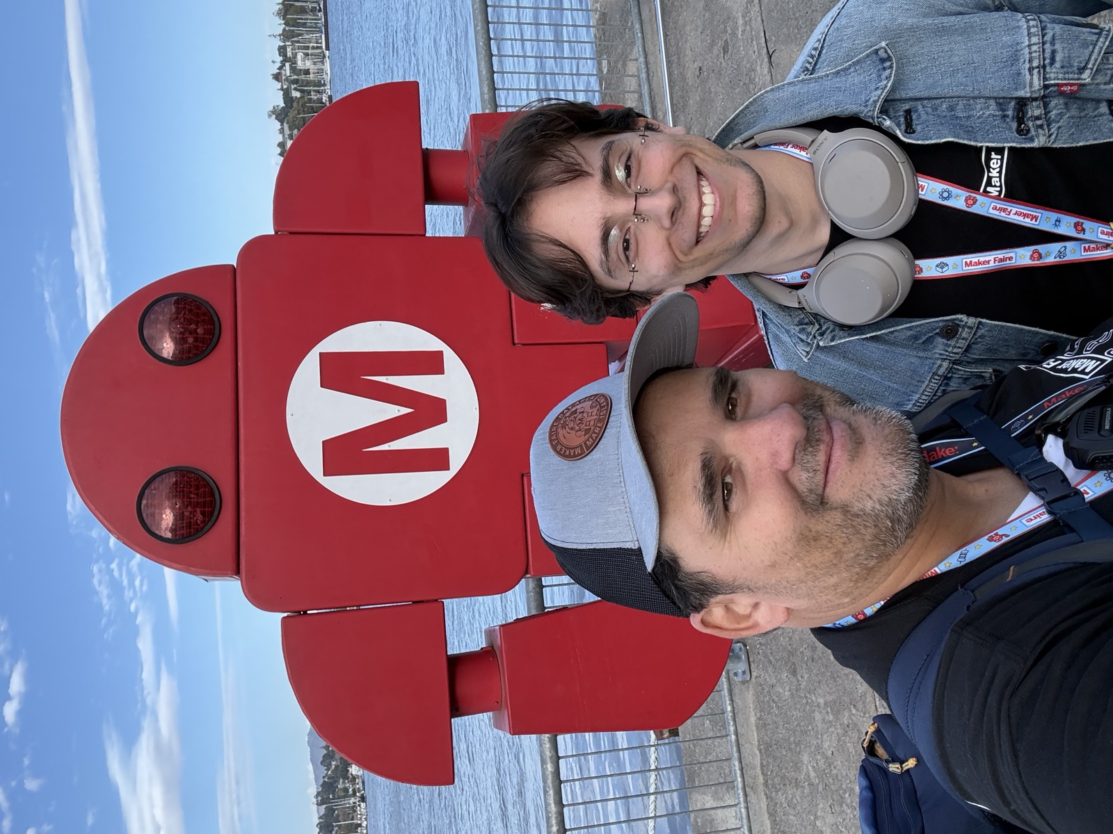 Selfie of Mario Cruz with Agusto in front of the giant red Makey robot on Mare Island