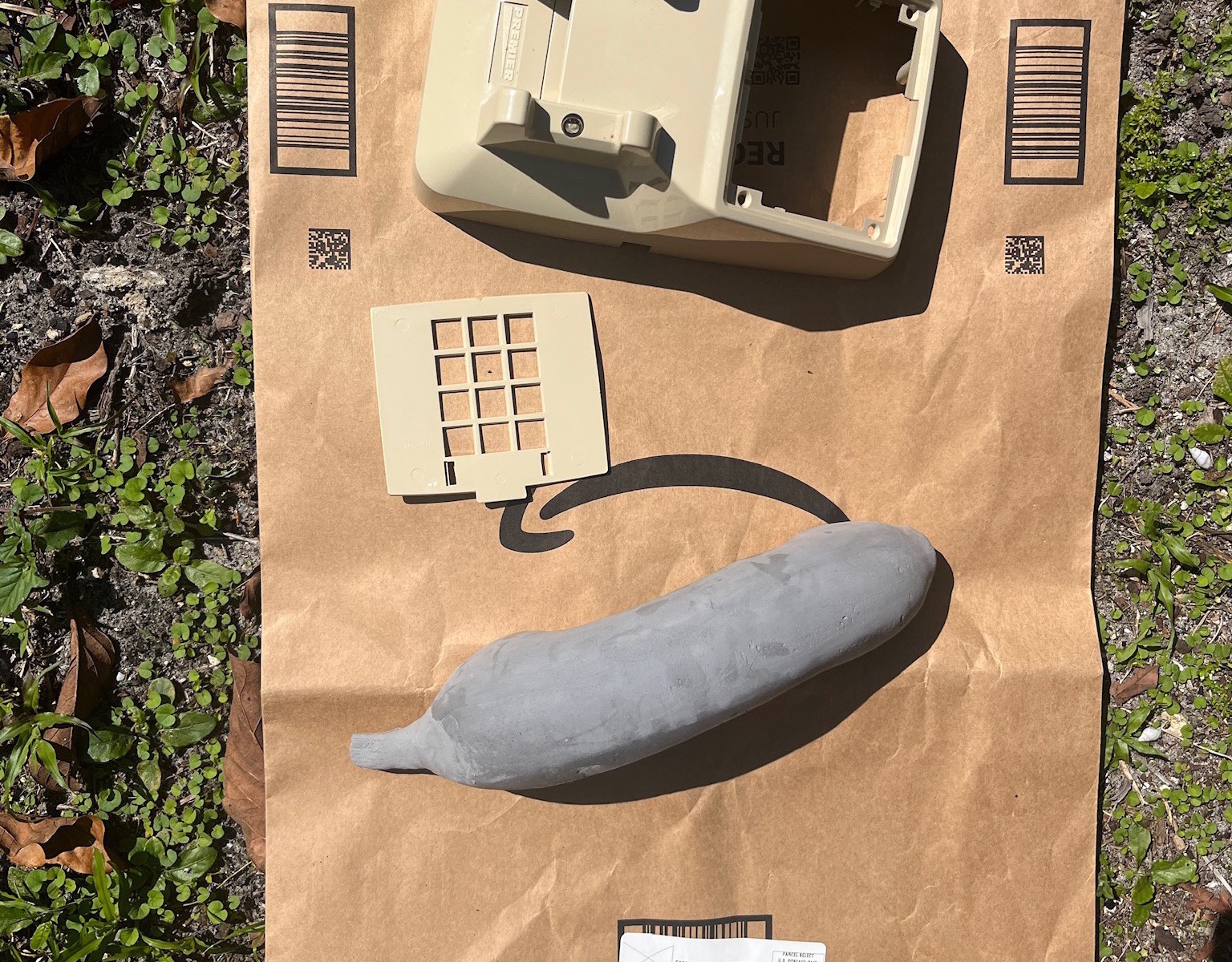 Phone parts disassembled on cardboard, ready for painting